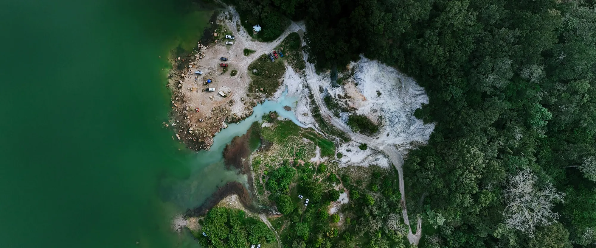 Laguna de Alegría from above — green water beside pale mineral deposits on the shore